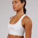 Woman wearing Rep Sports Bra Small Logo - White-Flamingo