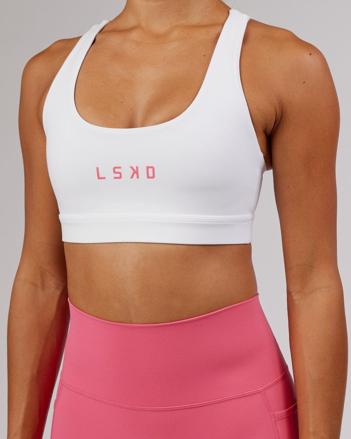 Woman wearing Rep Sports Bra Small Logo - White-Flamingo