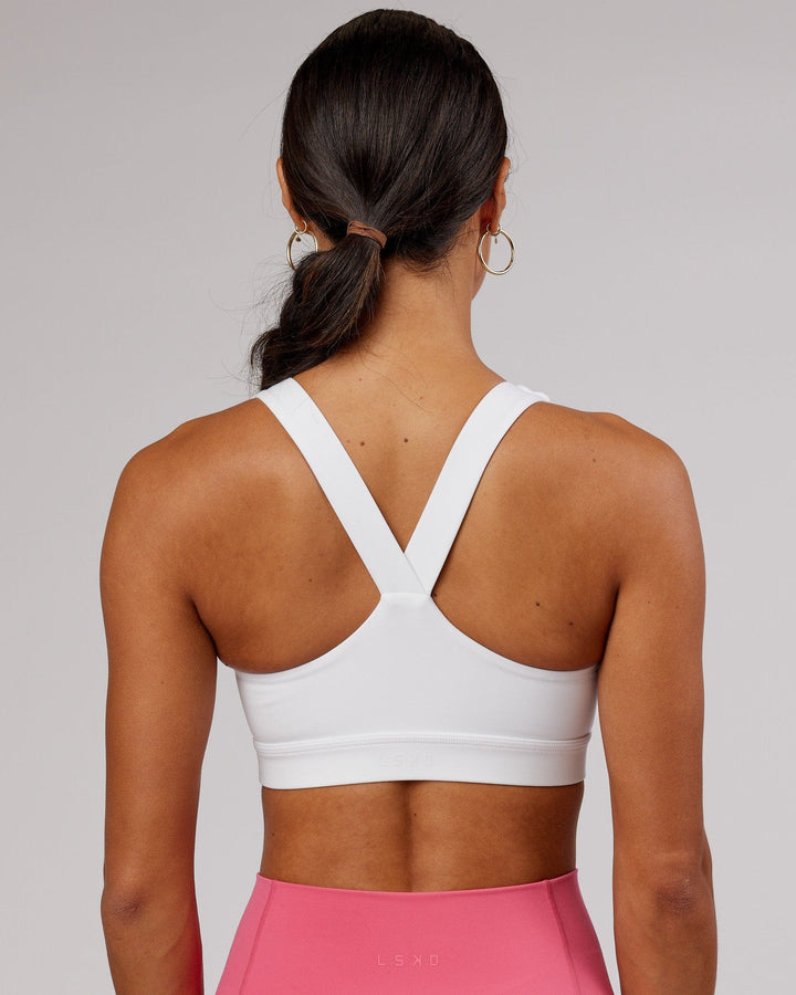 Woman wearing Rep Sports Bra Small Logo - White-Flamingo