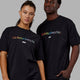 Man and Woman wearing Unisex 1% Better FLXCotton Tee Oversize - Pride-Black