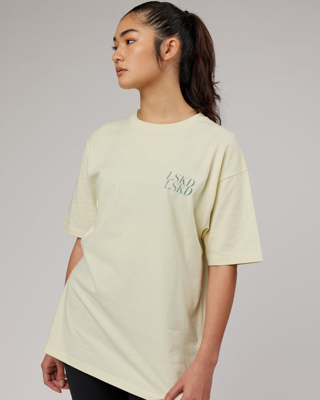 Woman wearingnUnisex Aurora Oversize Tee - Almond Milk
