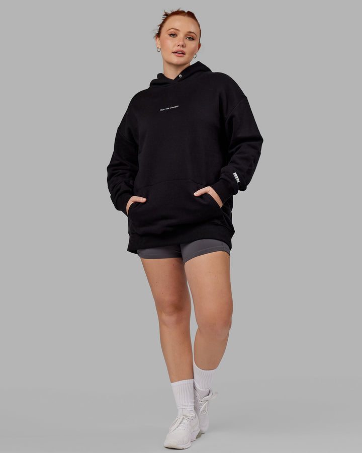 Woman wwearing Unisex Trust The Process Hoodie Oversize - Black