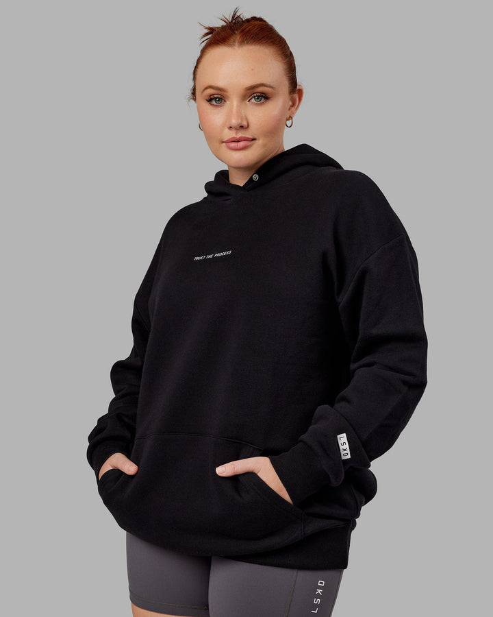 Woman wwearing Unisex Trust The Process Hoodie Oversize - Black