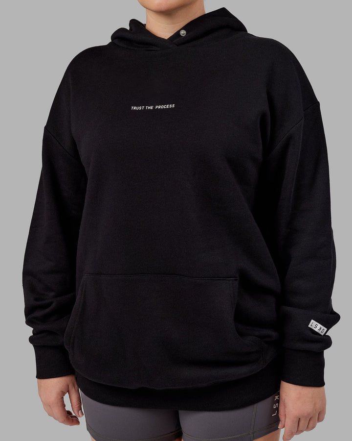 Woman wwearing Unisex Trust The Process Hoodie Oversize - Black