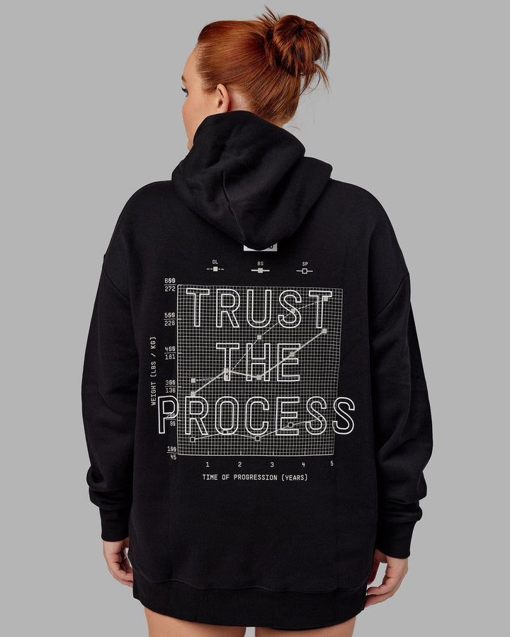 Woman wwearing Unisex Trust The Process Hoodie Oversize - Black